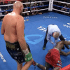 Tyson Fury looking over a knocked out Deontay Wilder