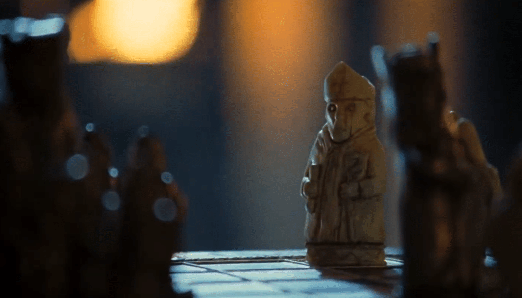 a scene from kingdom of heaven, showing a white king among black pieces on a chess board
