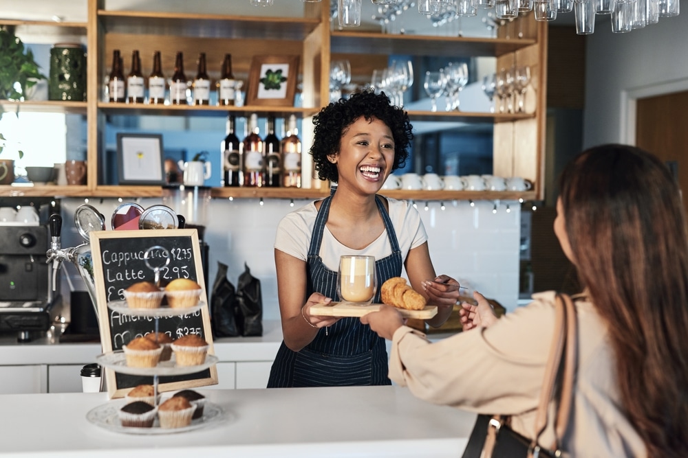 Young girl serving a customer in a coffee shop