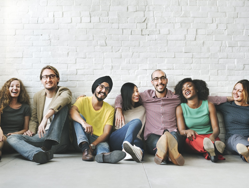 A group of people sitting together on the floor.