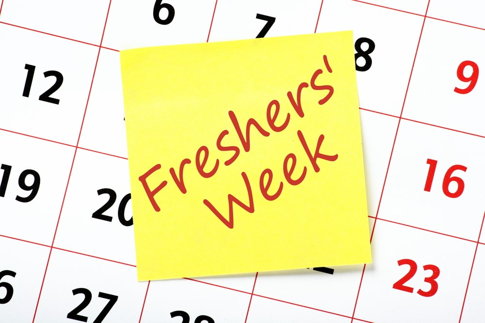 Post it note saying 'freshers week' in front of a calender