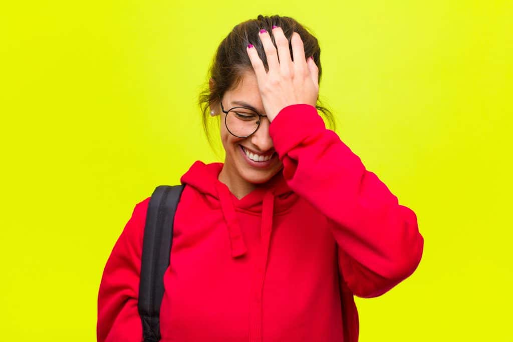 young woman hitting her forehead with her hand