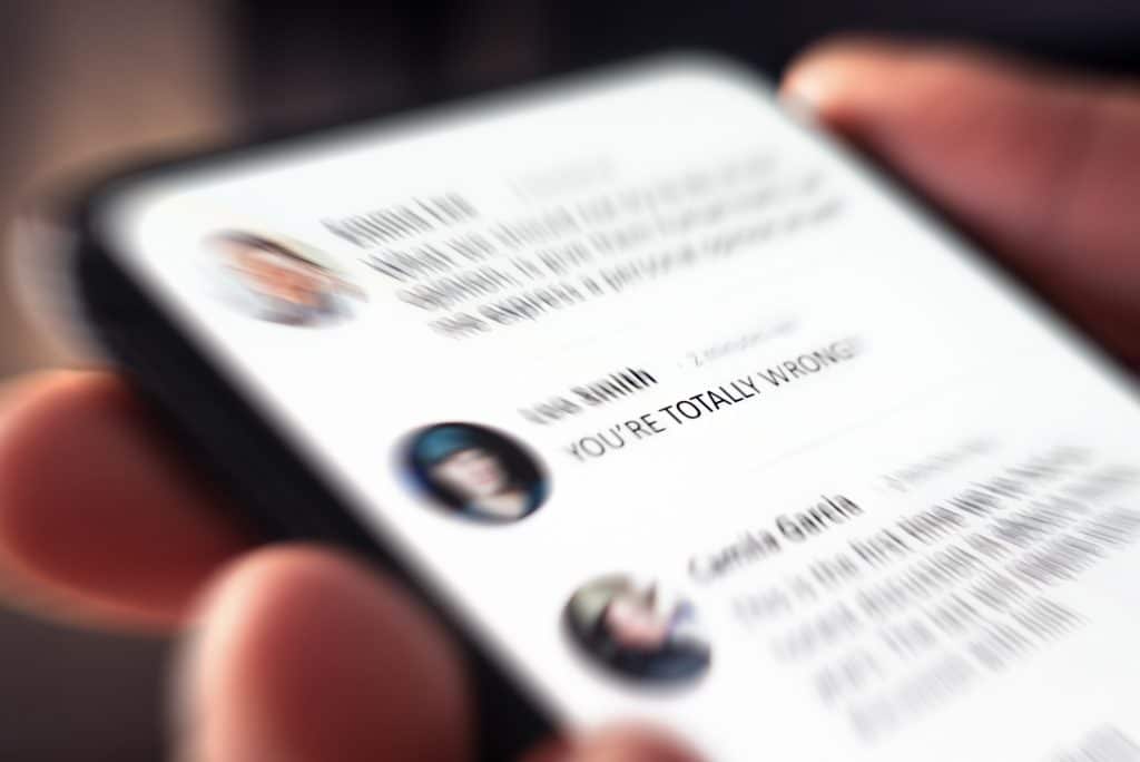 Phone screen showing comment saying "You're totally wrong"