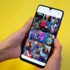 Two hands hold a phone showing a feed of videos on TikTok