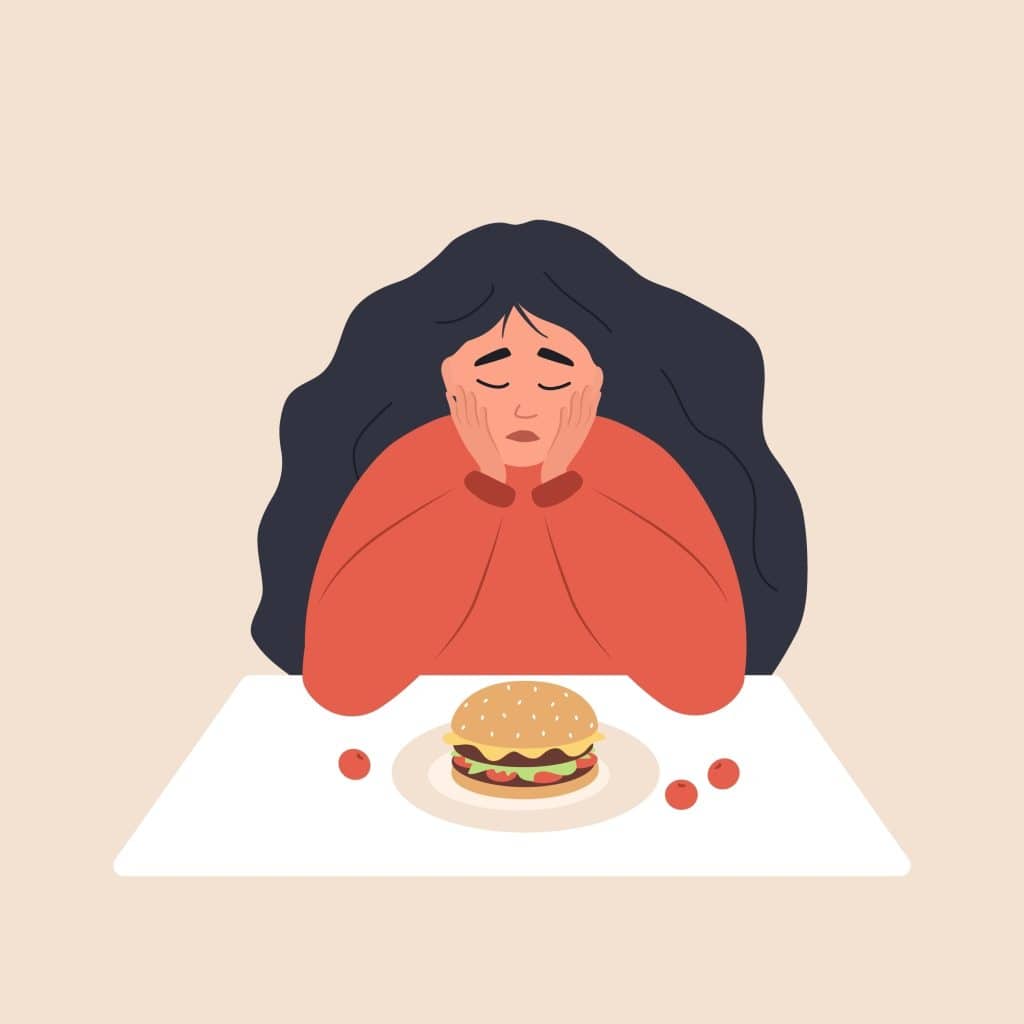 Woman looking depressed with cheeseburger