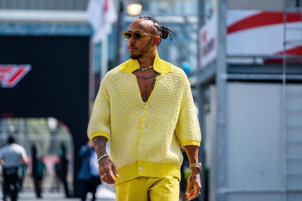 Lewis Hamilton entering the F1 paddock in Azerbaijan, Baku in a yellow cardigan, trousers, and sugnlasses
