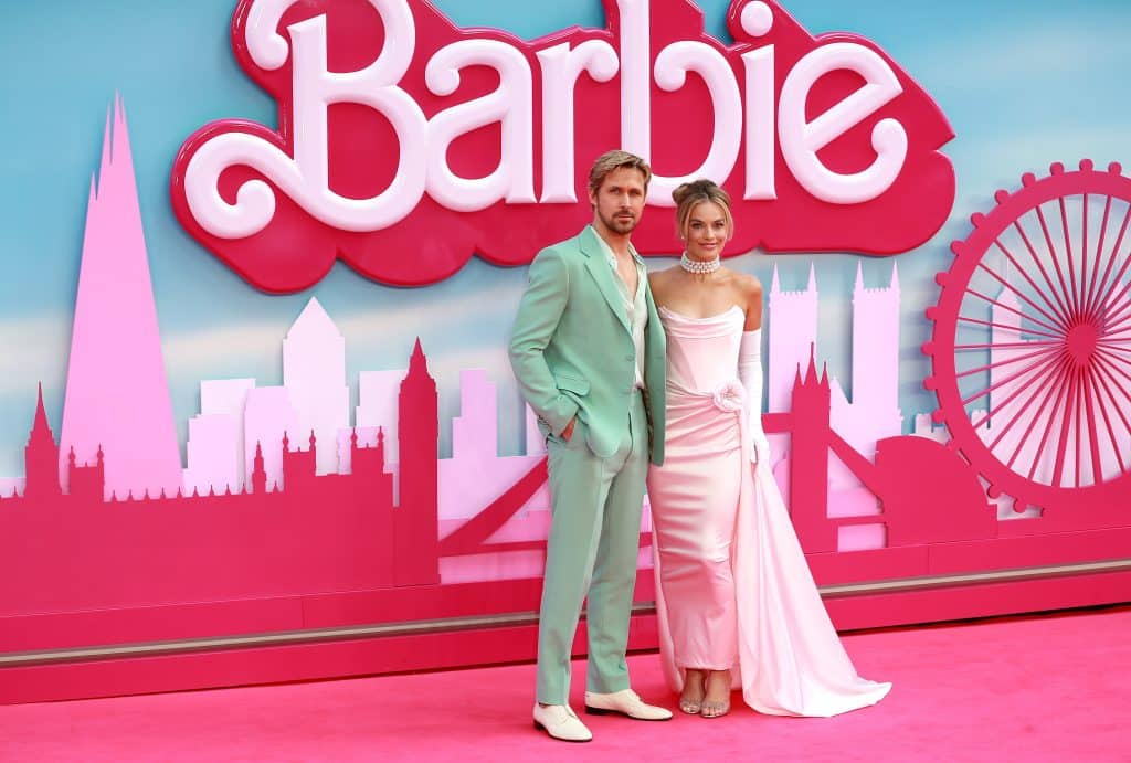 Ryan Gosling in a green suit and Margot Robbie in a pink dress promoting Barbie.