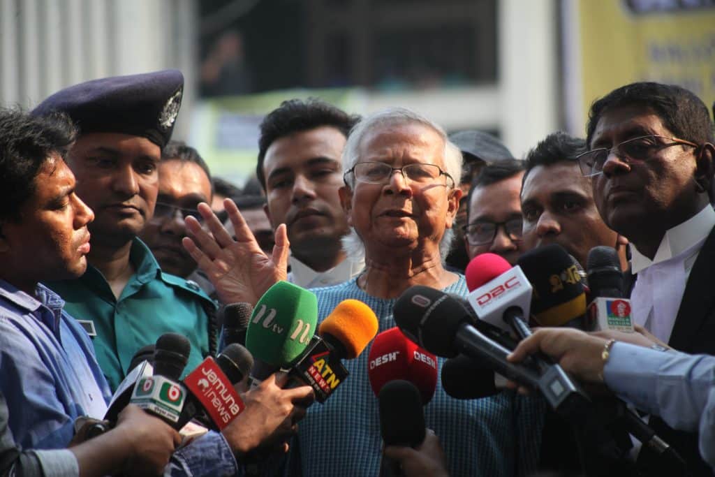 Muhammad Yunus surrounded by journalists