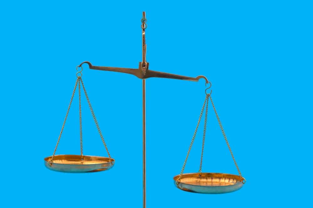 A golden scale of justice against a blue background. In this case, representing the weighing of the pros and cons of the gig economy.