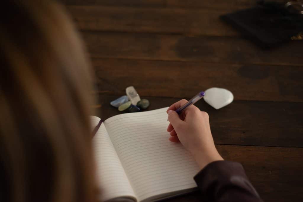 young woman writing in journal