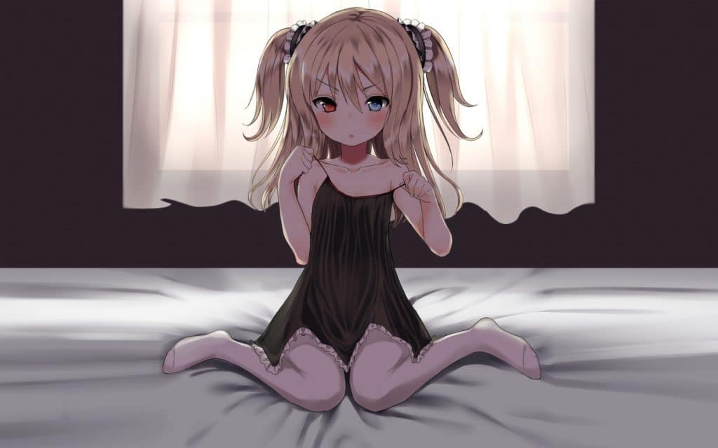 A small girl sits atop a bed. Her knees are together, wrinkling the sheets. She is dressed in black lingerie while her hair is styled in pigtails.