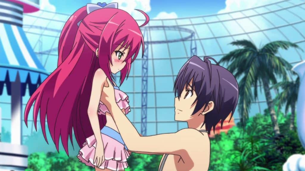 A small girl with bright red hair is held up by a teenage boy.
