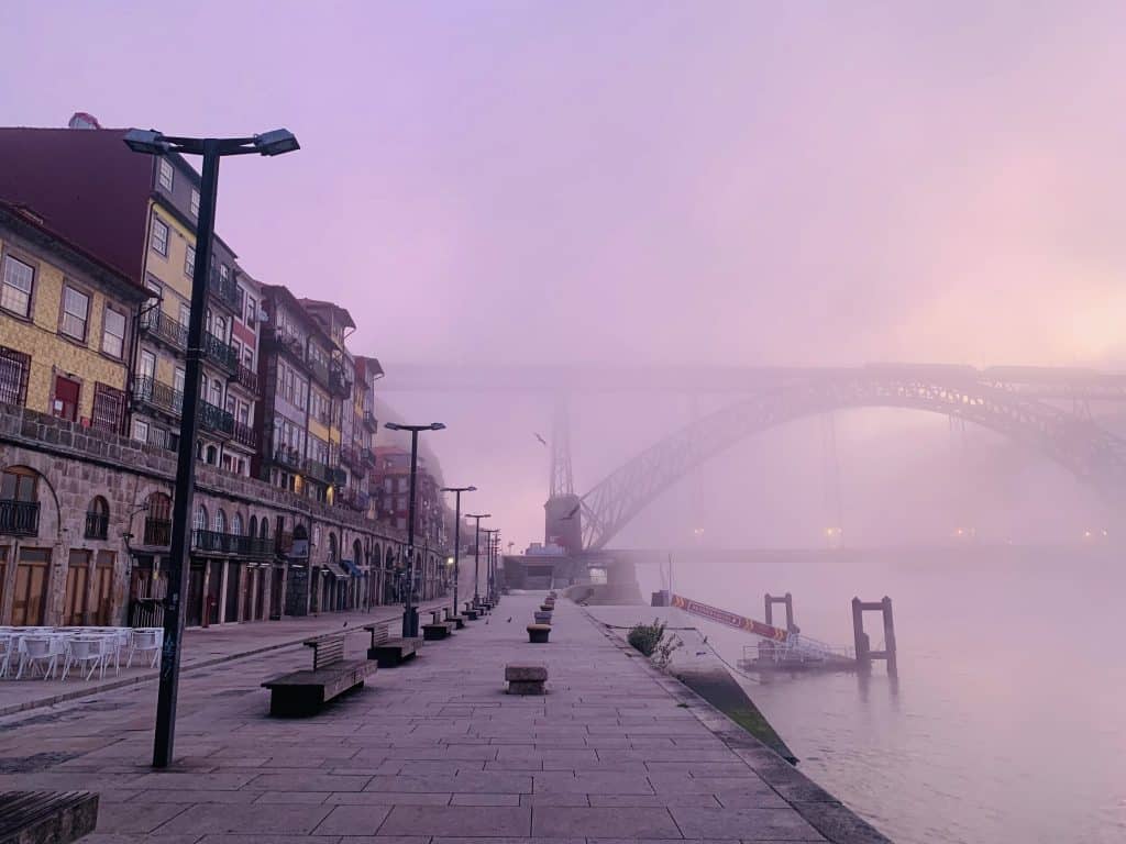 Street and bridge lit by purple predawn light