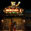 Still from 2023 Five Nights at Freddy's film showing exterior of the restaurant 'Freddy Fazbear's Pizza' lit up on a neon sign