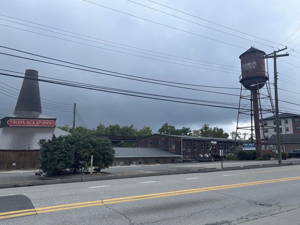 A cloudy day, with a landscape picture of stores in the college town of WVU in Morgantown in the front ground.