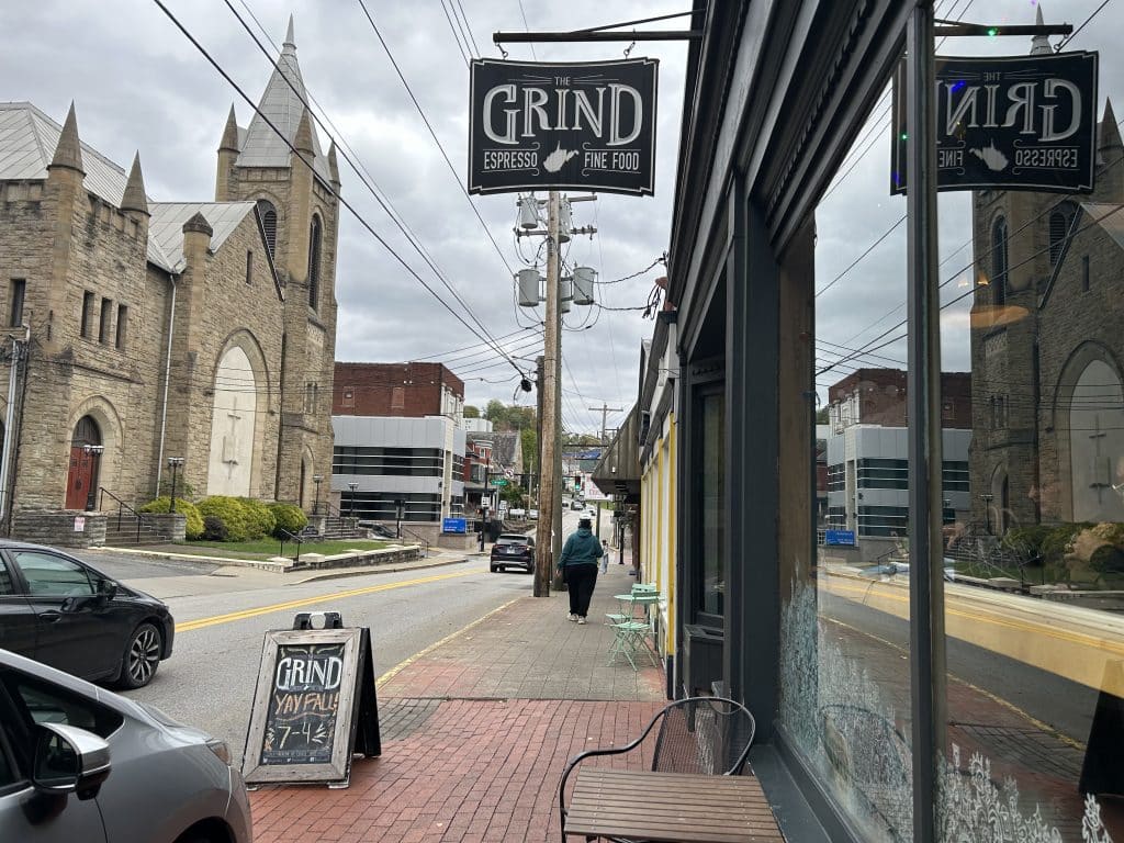 On a cloudy day, a picture of outside the grind, with a beautiful building in the background of this college town.