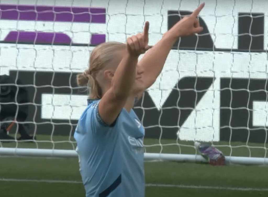 Erling Haaland pointing his fingers to the sky in celebration
