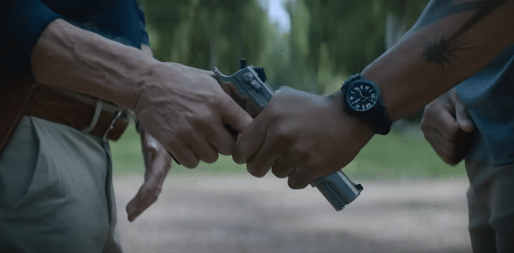 Terry grabs the chief's gun as the situation comes to blows in Rebel Ridge. Credit: YouTube/Netflix