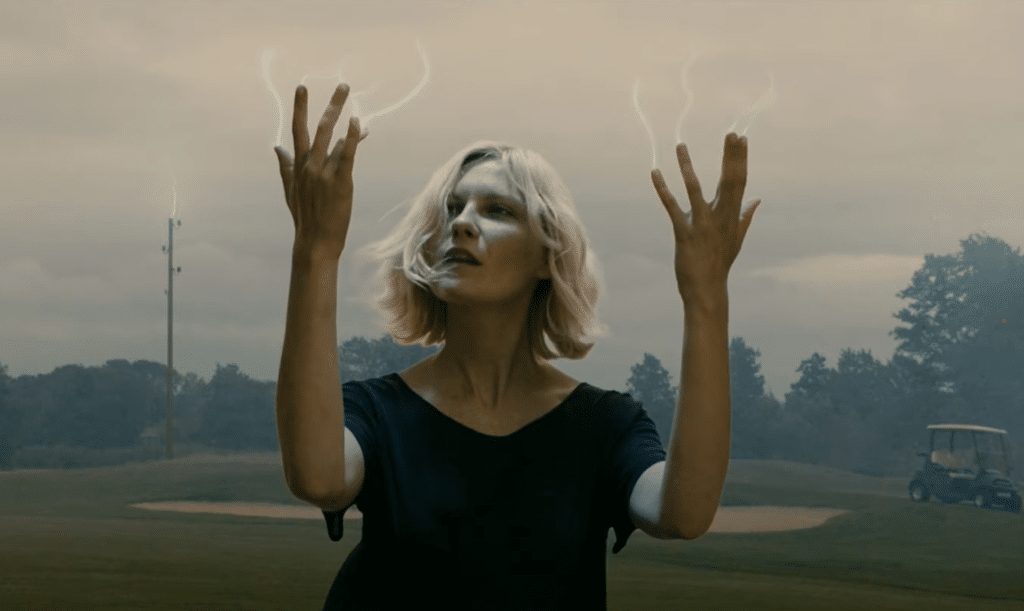 light streaks are appearing out of a blonde woman's hands.