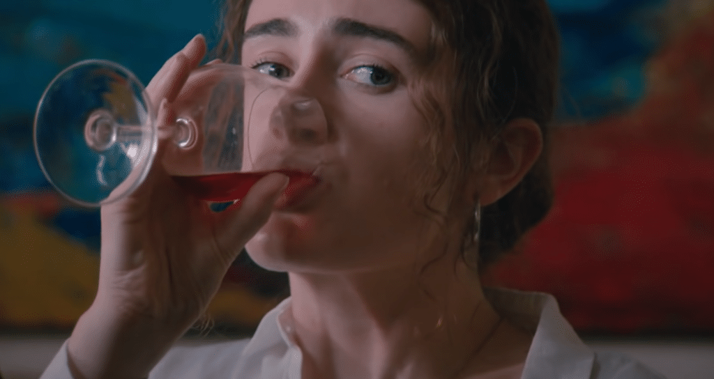 a girl is drinking wine.