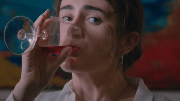 a girl is drinking wine.