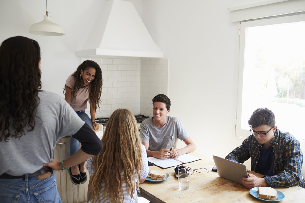 5 young people sat in a university accommodation kitchen