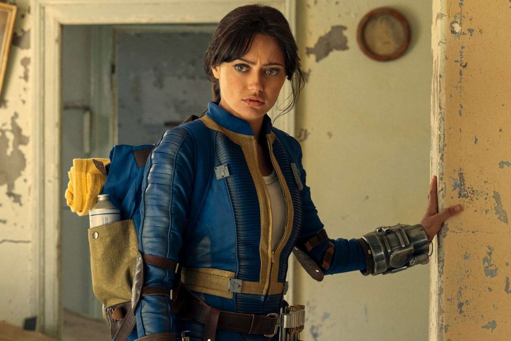 Lucy a white girl with dark hair wearing a blue jumpsuit with yellow accents. Game
