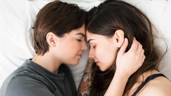lesbian couple cuddling in bed