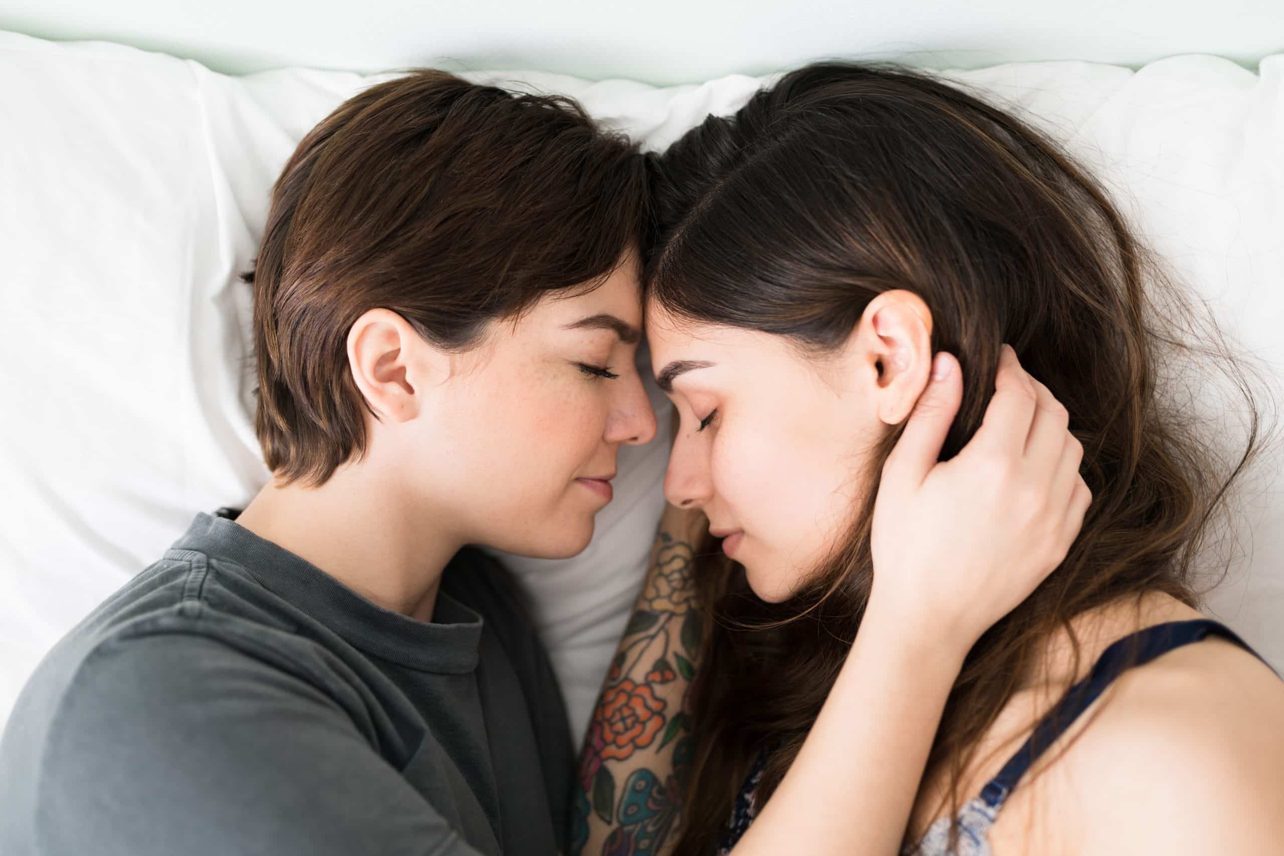 lesbian couple cuddling in bed