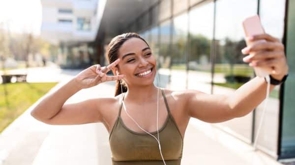 Young woman taking a selfie/ recording a video on the phone on the street