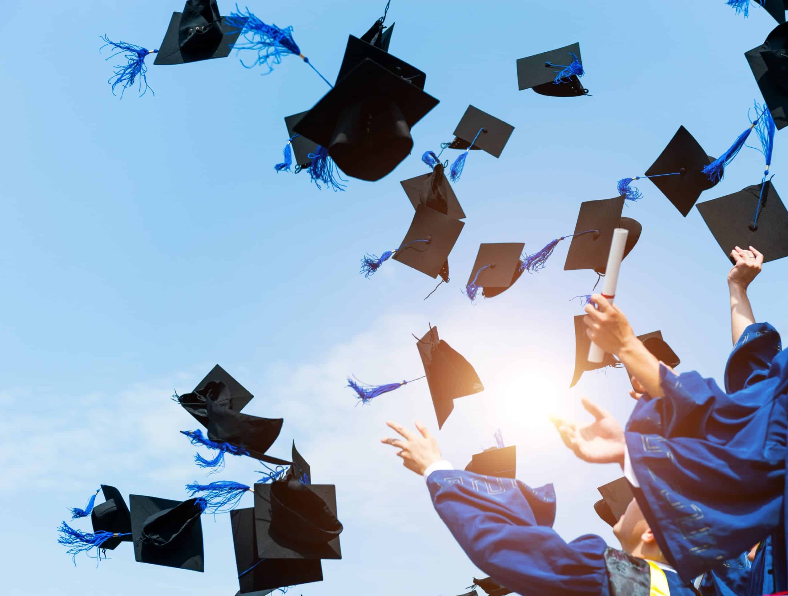 graduation caps in air