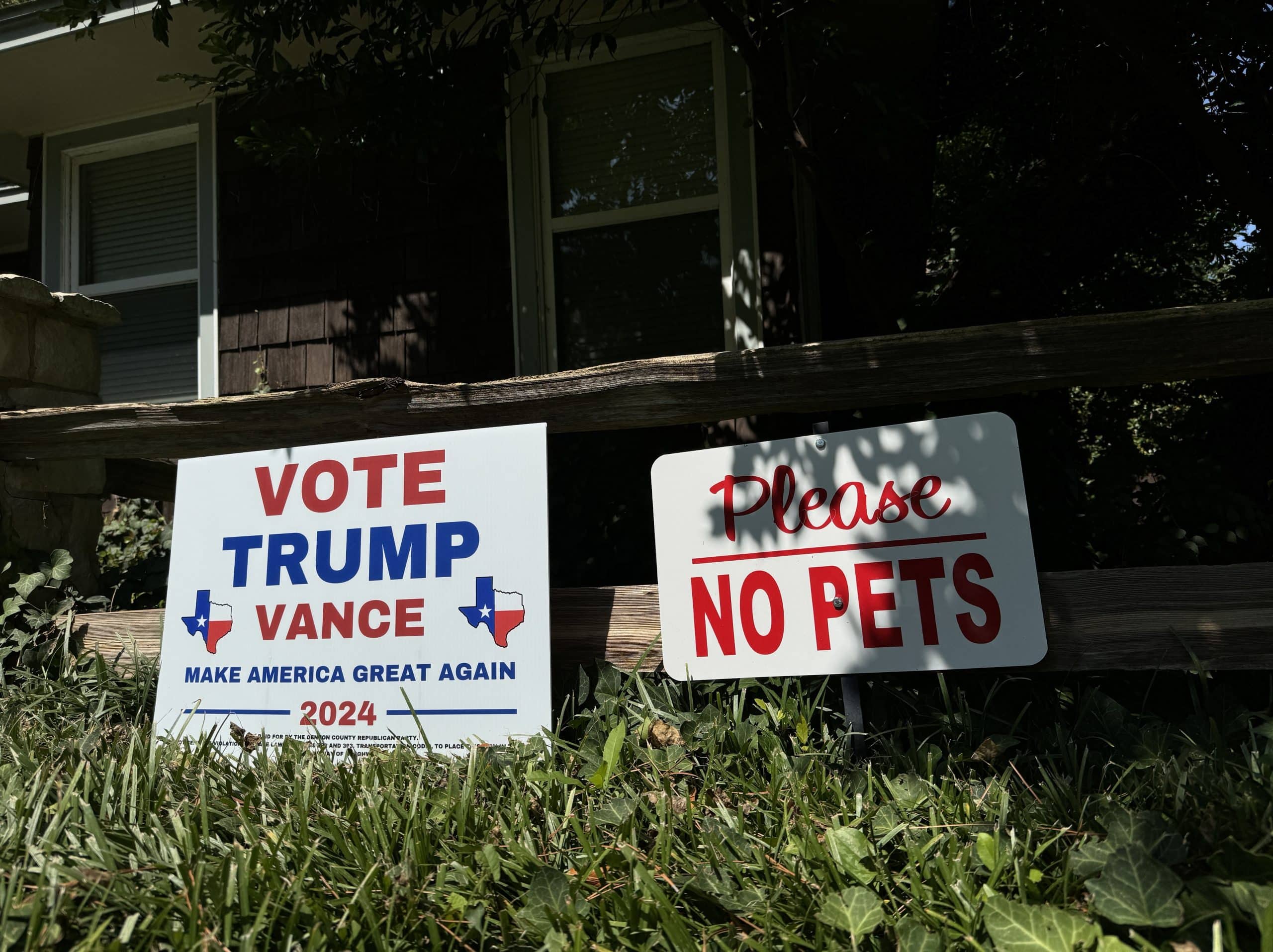 A Trump/Vance sign next to a 'No Pets' sign on a lawn.