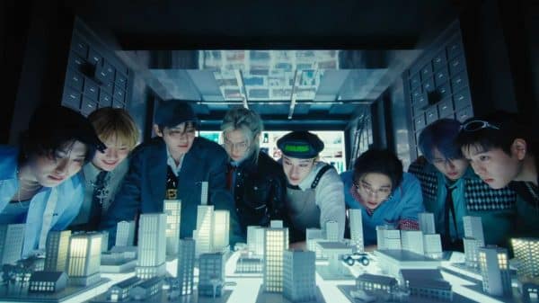 Stray Kids members looking over a model city.