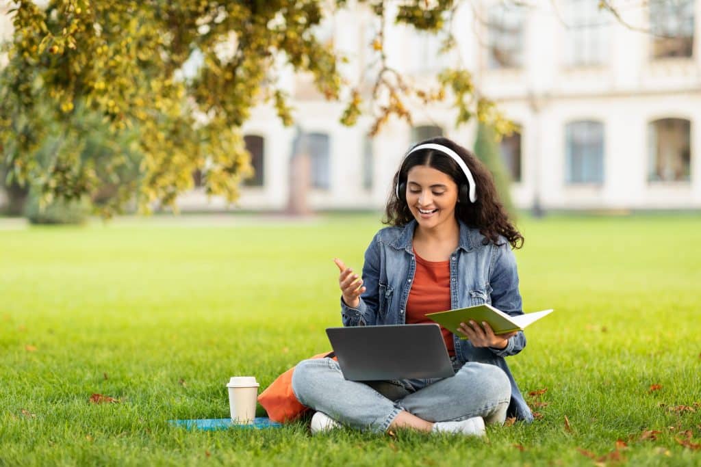 student studying outside sitting on grass