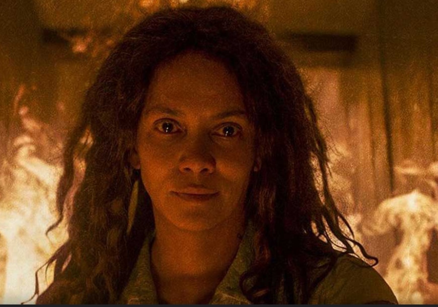 Halle Barry (Momma) stares menacingly at us while fire blazes behind her.