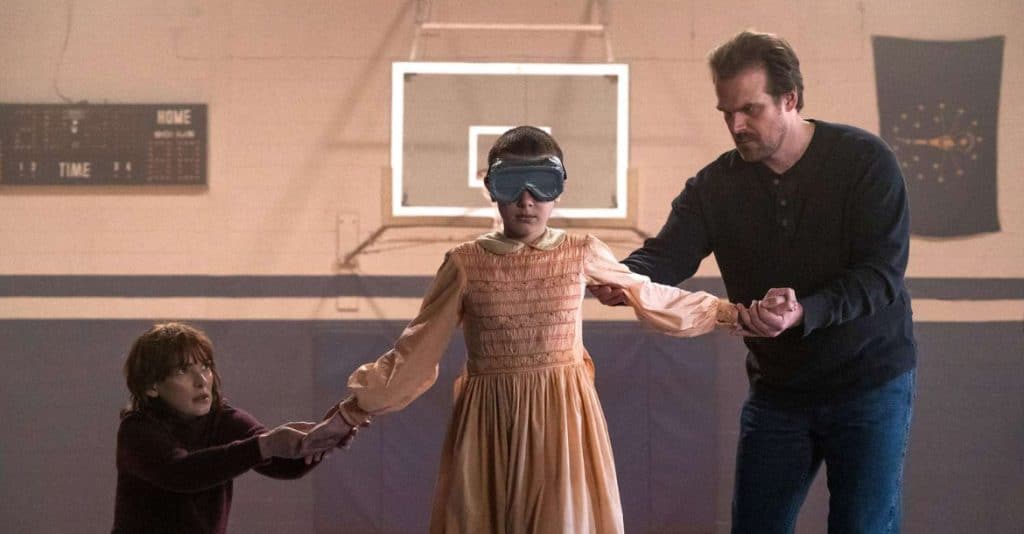Man and Woman gently assist a blinded folded girl.