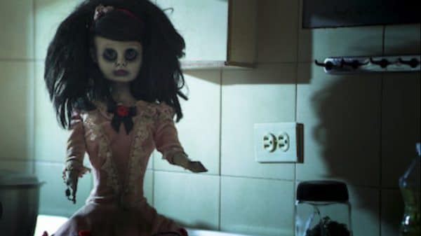 An ugly doll sits eerily of the counter.