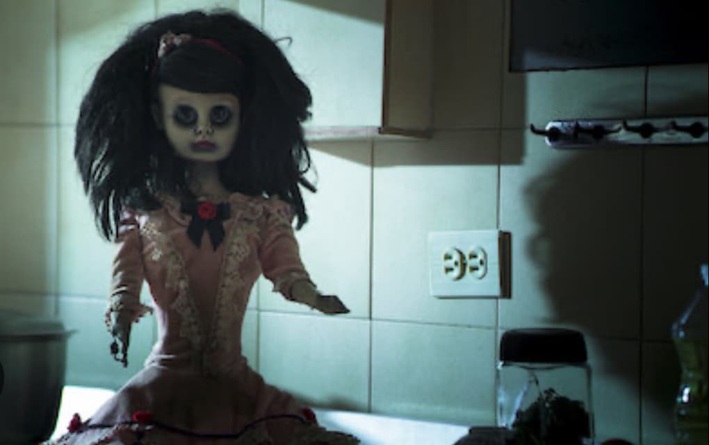 An ugly doll sits eerily of the counter.