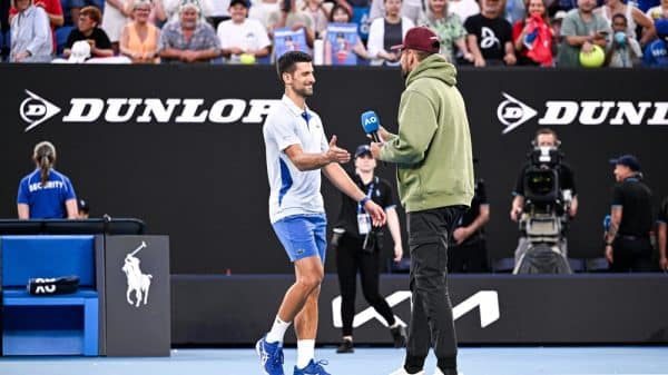 Nick Kyrgios and Novak Djokovic on a tennis court, Kyrgios is interviewing Djokovic