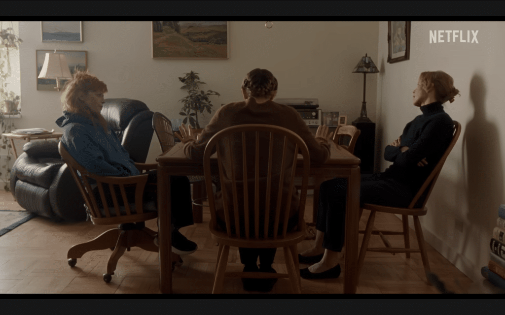 A screenshot of the trailer for "His Three Daughters" showing the three main leads sitting together at a dining table.