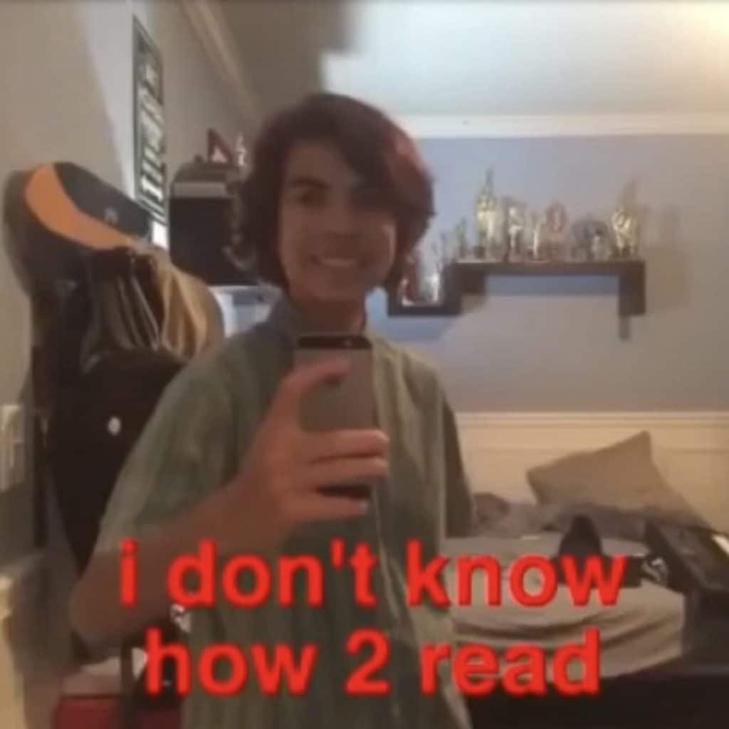 A teenager holds up a phone with the caption "I don't know how to read"