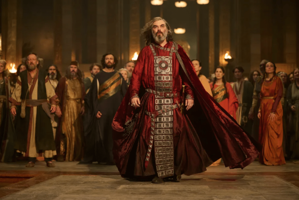 Still from Rings of Power: Pharazôn in foreground wearing a red robe