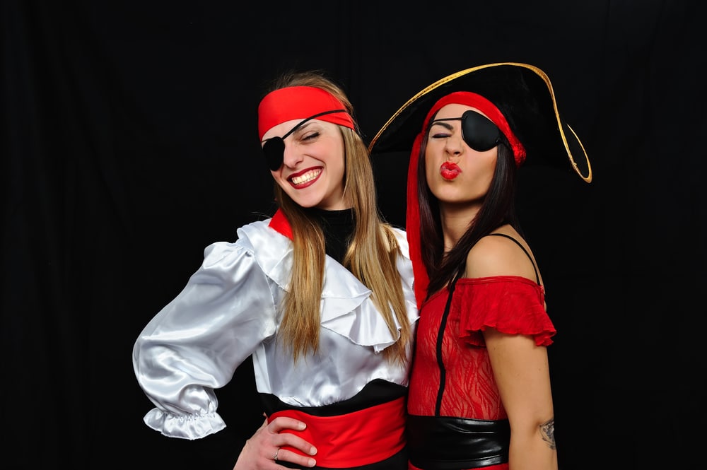Two teenage girls pose wearing pirate costumes for Halloween.