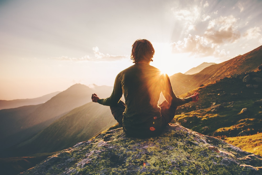Man meditating on a mountain top