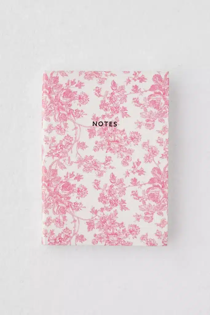 A pocket-sized journal with a rose-colored floral print.