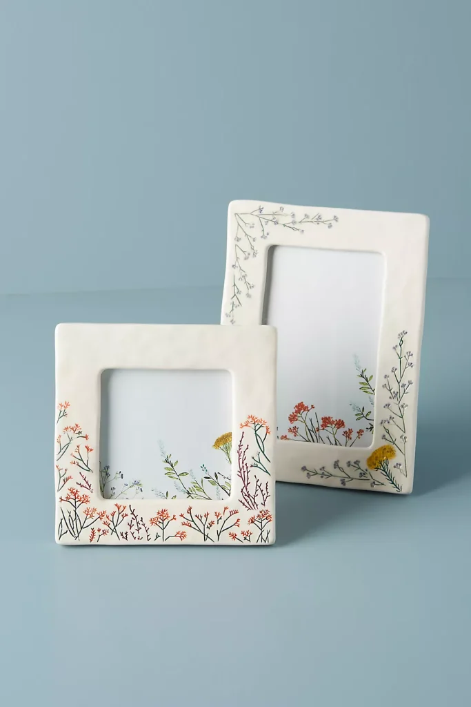 Hand-painted botanical designs on ceramic frames.