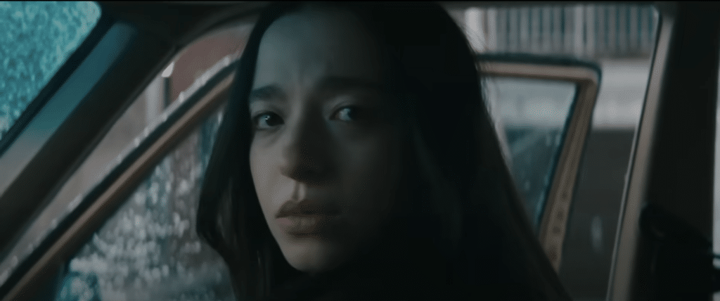 Mikey Madison as Ani staring into the camera in the film, Anora.