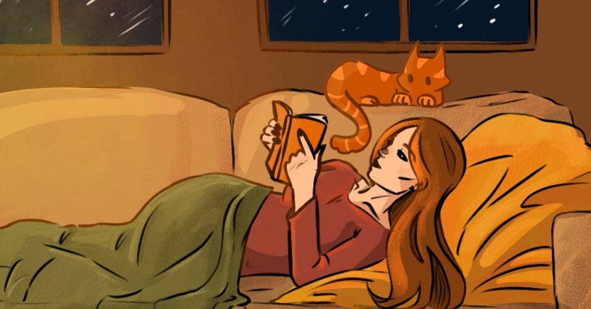 Girl reading on the couch with a cat