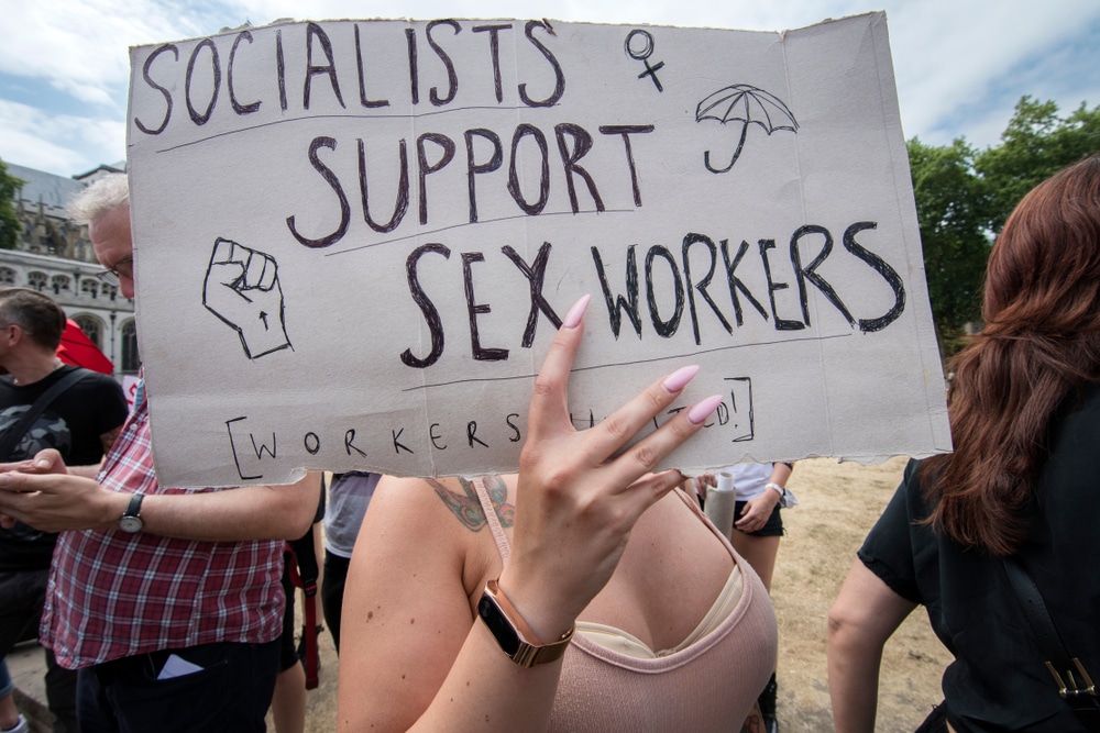 A person holding up a sign that says "Socialists support Sex Workers."