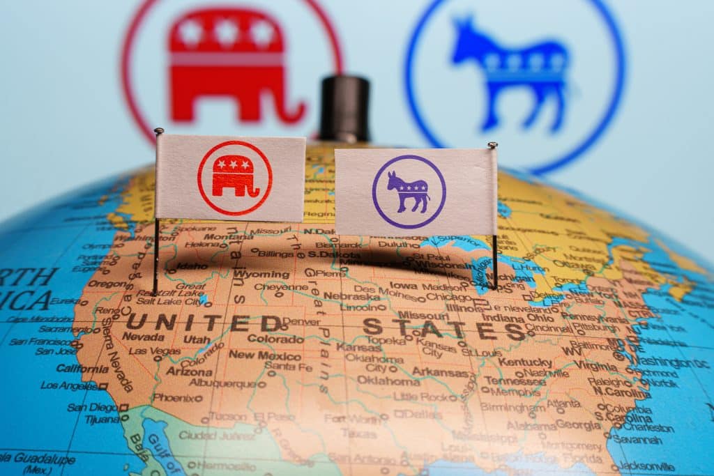 Republican Party and Democratic Party logos on the United States of America political map. Credit: Shutterstock/Rokas Tenys